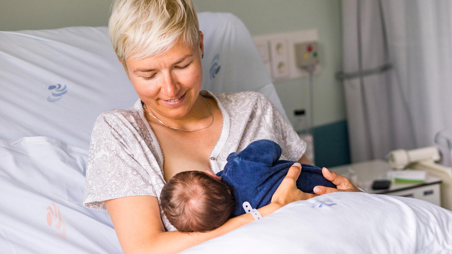 Mama trzyma dziecko pijace mleko z jej piersi w szpitalu