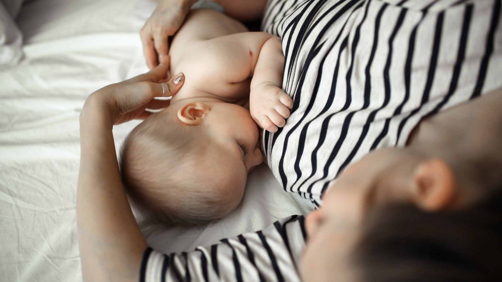 Mama karmi dziecko piersia lezac bokiem