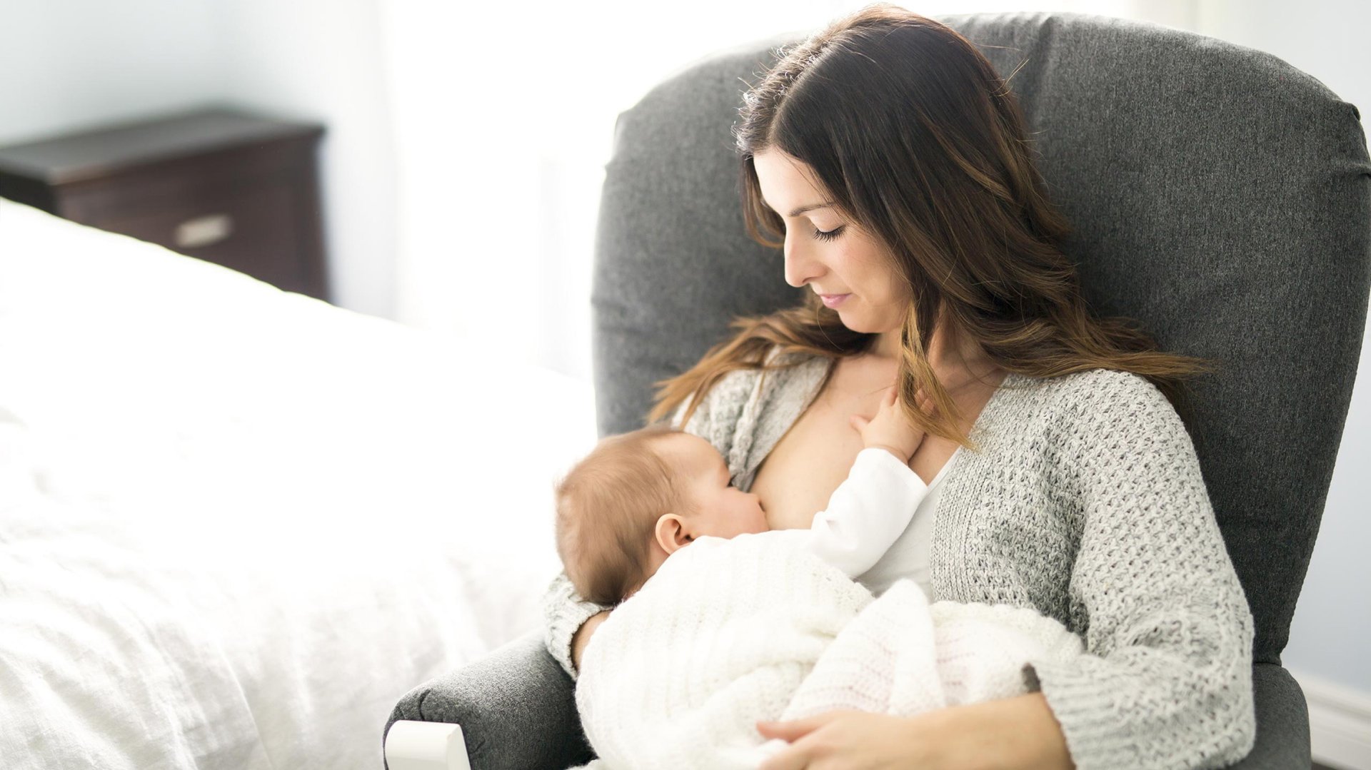 Mama karmi dziecko piersia siedzac w fotelu