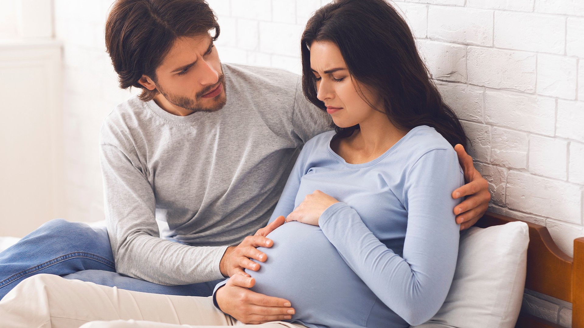 Mezczyzna wspiera kobiete cierpiaca na bol brzucha ciazowego